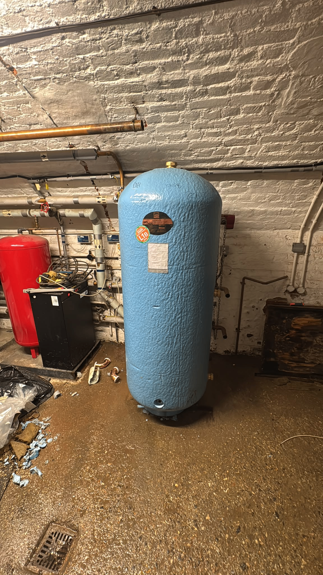 Blue pressurised vessel positioned in a basement plant room during hot water system upgrade works