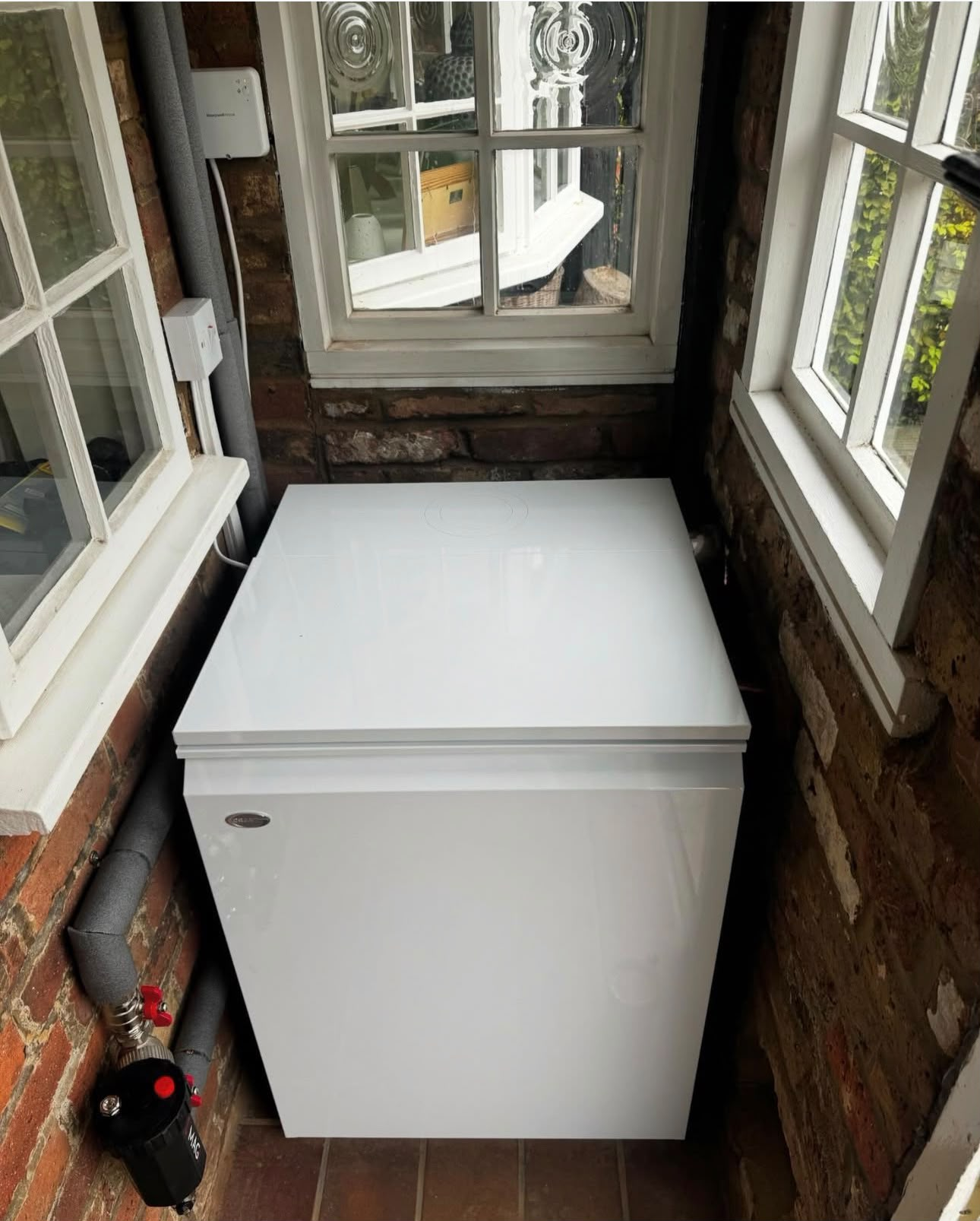 External oil tank installation positioned neatly between brick walls