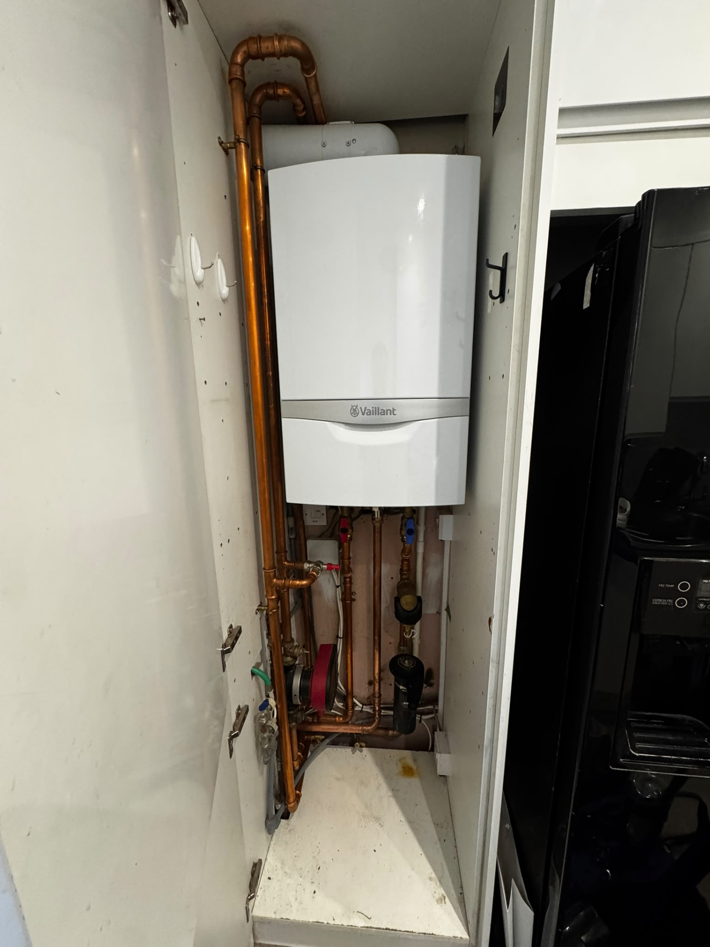 Vaillant boiler fitted inside a tall cupboard with concealed services and tidy copper pipework