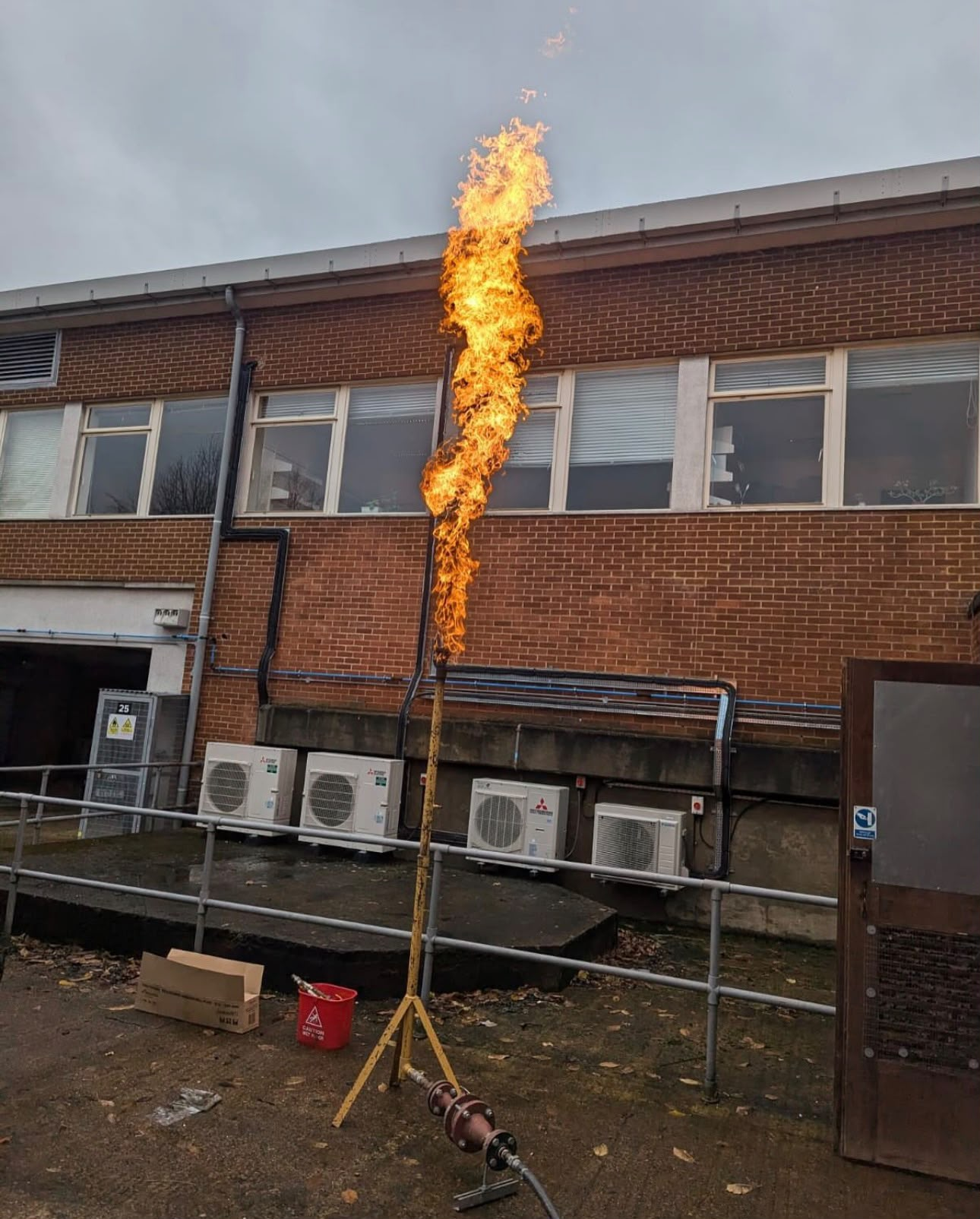 Commercial gas purge and flame testing setup outside a brick building
